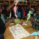 Children decorating a cake on a table