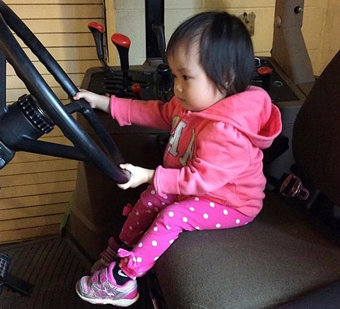 child sitting at steering wheel